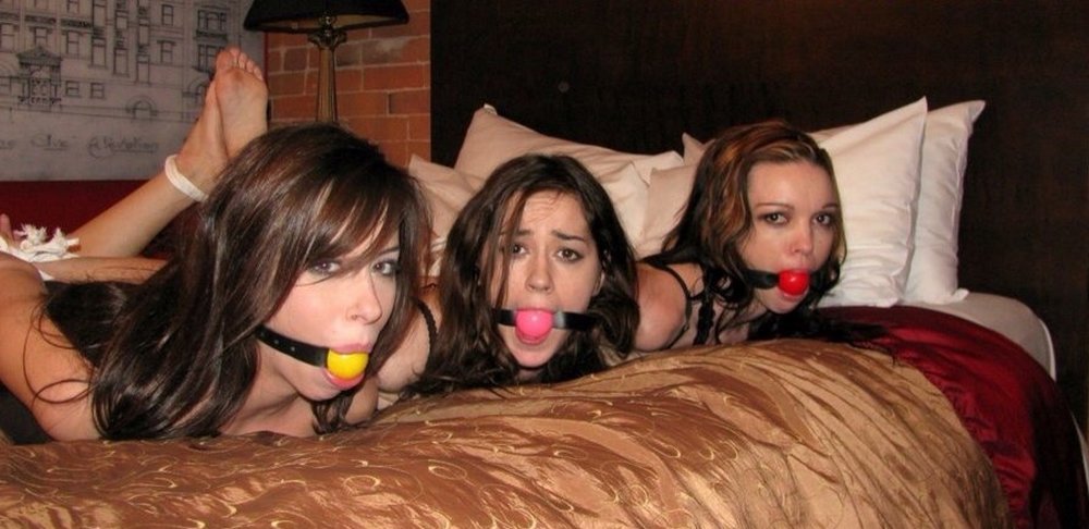 three women hogtied and wearing ball gags